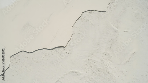 Cracked white surface, textured lines and crevices.
