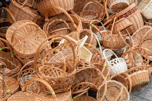 Fotografie Large pile of traditional handmade wicker baskets at an outdoor market, woven ra