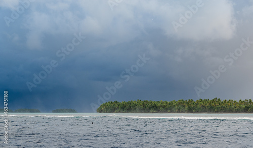 Storm approaching an Island while waves are crashing over the reef barrier
