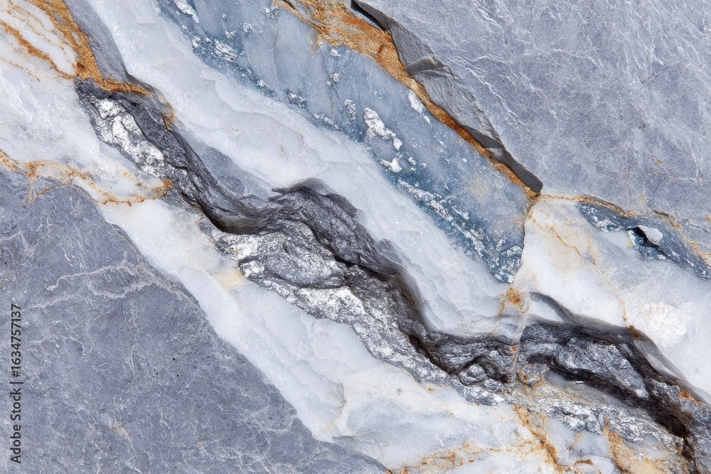 Fototapeta premium Silver veins running through rough gray and blue rock formation