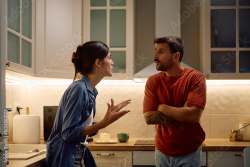 Behang Displeased couple arguing in kitchen.