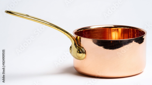 shiny copper saucepan placed on a reflective surface