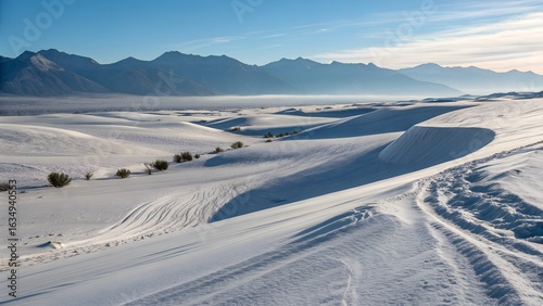 windswept snow dunes and distant mountains under