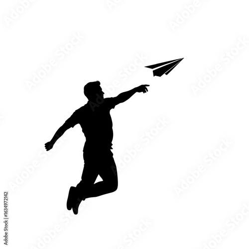 Silhouette of a man jumping and throwing a paper airplane into the air with his right hand extended