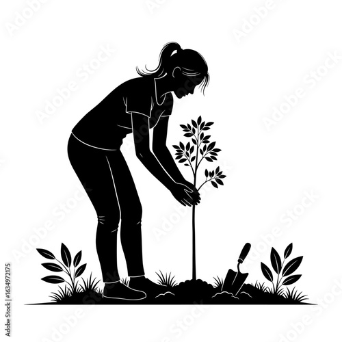 Female silhouette planting a young tree with trowel in grass conservation and environmental care