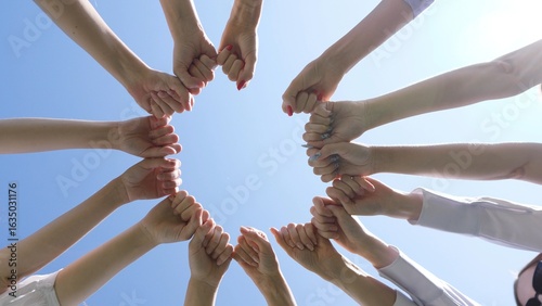 Friends make hand shapes against a blue sky background