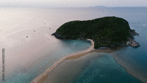 Aerial view of a sandy isthmus connecting a verdant island to the mainland, embraced by the turquoise sea, Ko Ma Beach, Koh Phangan, Thailand.