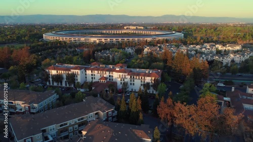Aerial view of Apple Park, the corporate headquarters of Apple, surrounded by trees and buildings in Cupertino, California, USA.  