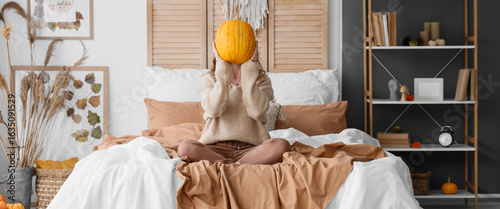 Young woman with pumpkin si...