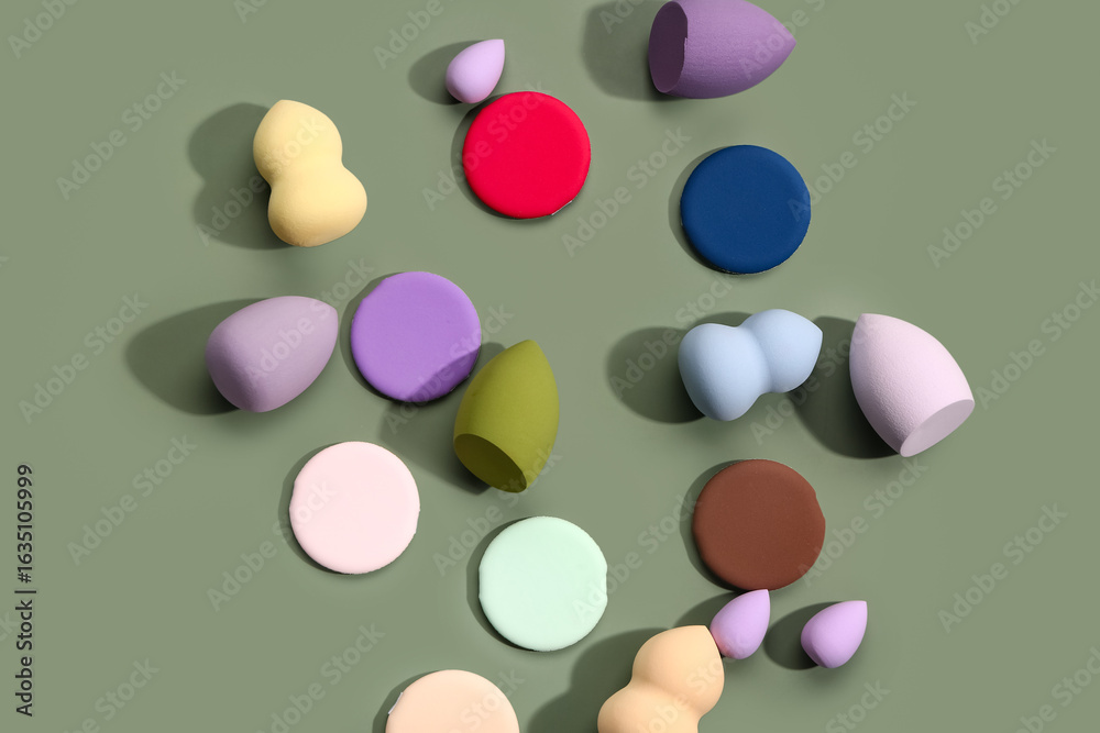 Fototapeta premium Different makeup sponges on green background