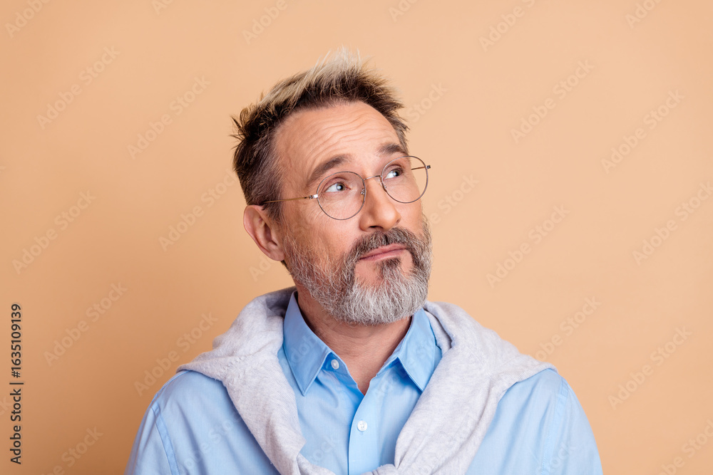 Obraz premium Portrait of a mature businessman thinking with a thoughtful expression, casual stylish attire, and trendy facial hair