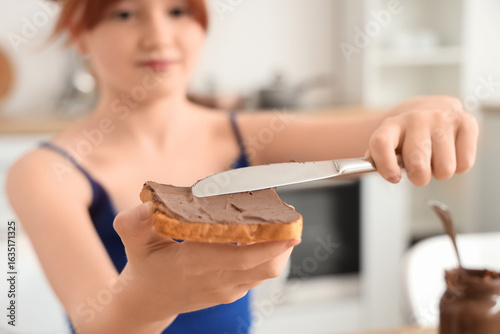 Cute girl making toast with...