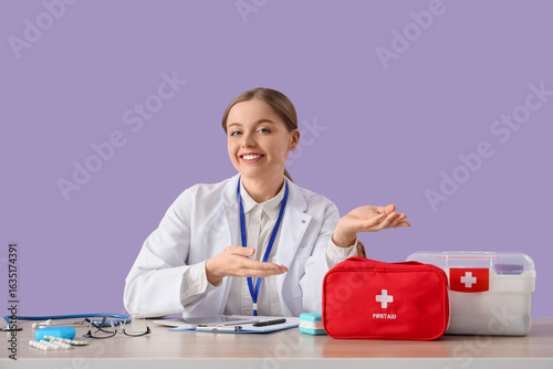 Female doctor with first aid kits, medicine and clipboard sitting at table on...