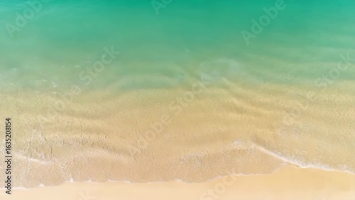 Top-down view of a sandy beach with blue water and waves, web banner design with copy space on the right for text or graphics