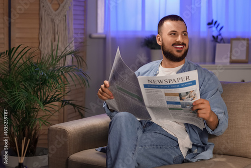 Smiling young man reading n...