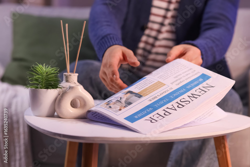 Young man taking newspaper ...