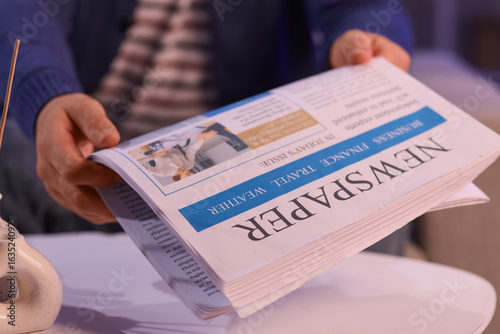 Young man taking newspaper ...