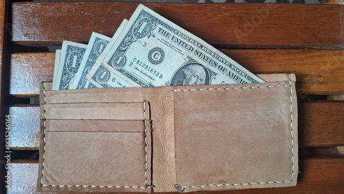 Elegant leather wallet with dollar bills inside
