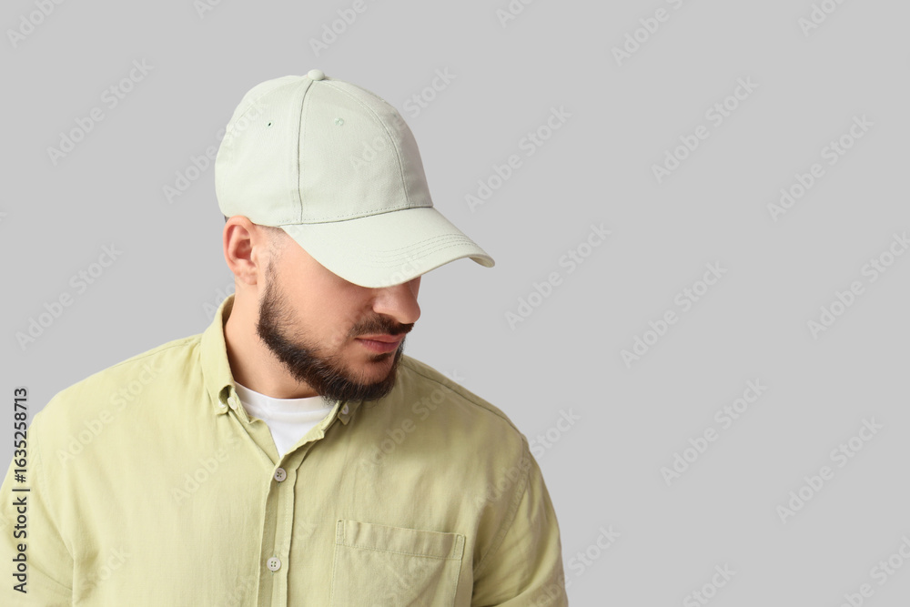 Handsome young man in stylish cap on grey background Handsome young man in stylish cap on grey background