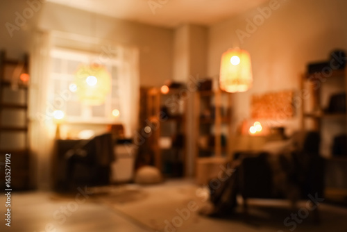 Wallpaper Mural Blurred view of stylish living room with armchair, workspace, glowing lamps and bookshelves at evening Torontodigital.ca