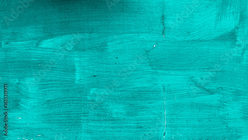 Close-up of aqua painted wall with visible brush strokes, cracks, and subtle imperfections on the surface.