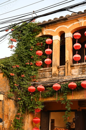 Fototapeta Naklejka Na Ścianę i Meble -  The ornate entrance to a small restaurant and coffee shop on one of the streets of the old town in Hoi An, Vietnam on a hot summer day at sunset