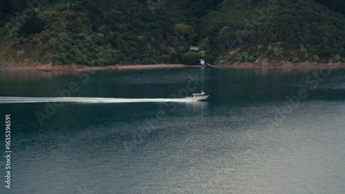 A small fishing boat passing along a lake
