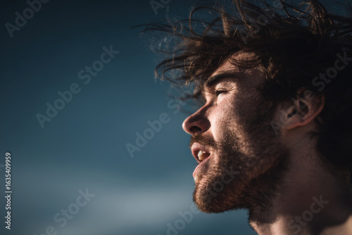 profile portrait of man with his mouth open taking deep breath under intense sunlight