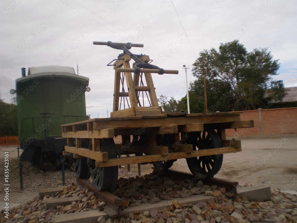 Obraz premium A wooden cart with a metal handle is sitting on a train track