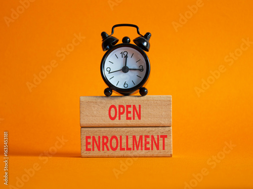 Open Enrollment symbol. Wooden blocks with words Open Enrollment. Beautiful orange background with alarm clock. Business and Open Enrollment concept. Copy space.