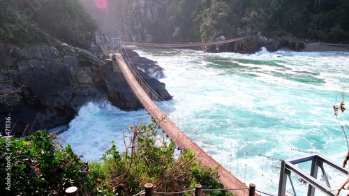 Frothing sea waves roll in under suspension footbridge at Storms River mouth