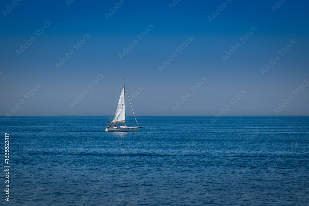 Fototapeta premium open sea. a white sailboat is sailing.