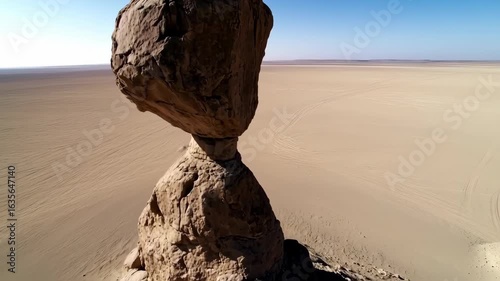 Balancing Rock Formation in Vast Desert Landscape Under Clear Blue Sky
