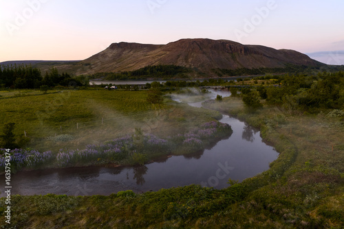 Fog crawling over river at sunset near úlfarsfell mountain