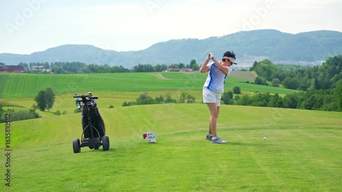 Wallpaper Mural Active senior woman playing golf on a scenic course with rolling hills, enjoying outdoor exercise and vibrant retirement on a sunny summer day. Torontodigital.ca