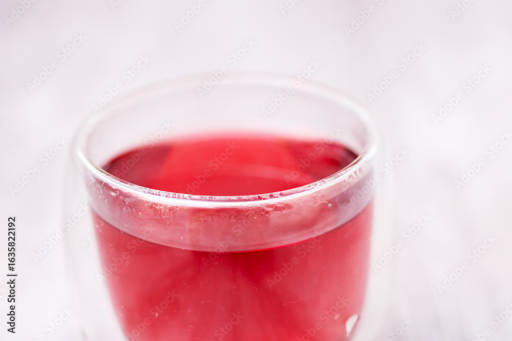 This is a detailed closeup image of a glass containing red liquid This is a detailed closeup image of a glass containing red liquid