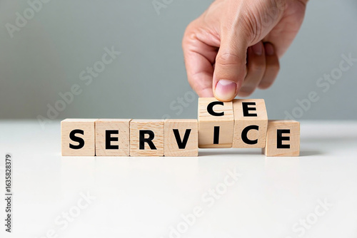 Hand arranging wooden blocks spelling out the word service