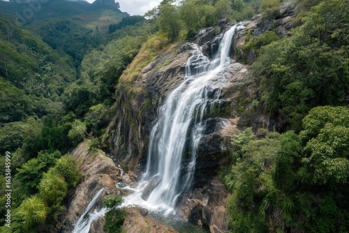 Majestic waterfall cascading down rocky cliffs in a lush forest setting