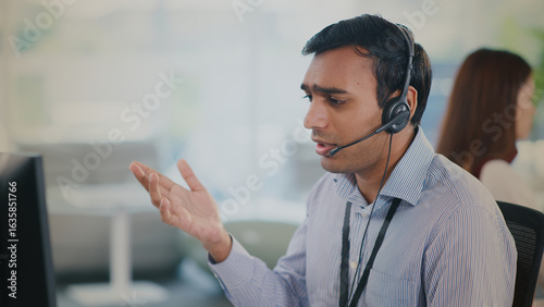 Foto Focused male agent provides helpful tech support and excellent customer service from modern call center