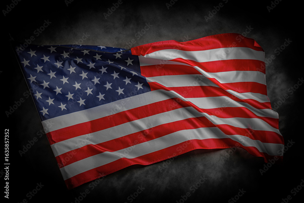 Obraz premium A dramatic image of the American flag waving against a dark cloudy background