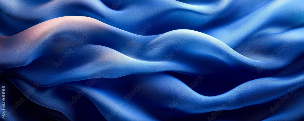 Obraz premium Blue fabric flows smoothly. A vibrant blue fabric undulates gracefully, showcasing fluid movements and soft textures in natural light.