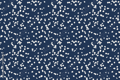 Seamless pattern of tiny white floral dots, small spots, little drops scattered across a navy background. This playful, minimalist design  for print, textiles, gift wrap, wallpapers, stationery