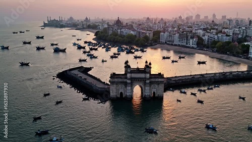 Gateway of India at sunset with boats in the water and city skyline in the background