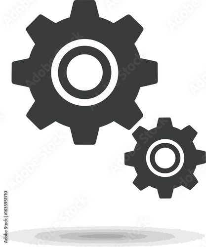 Two dark grey gears, one large and one small, interlocked and casting a shadow on a white background, symbolizing teamwork and industry