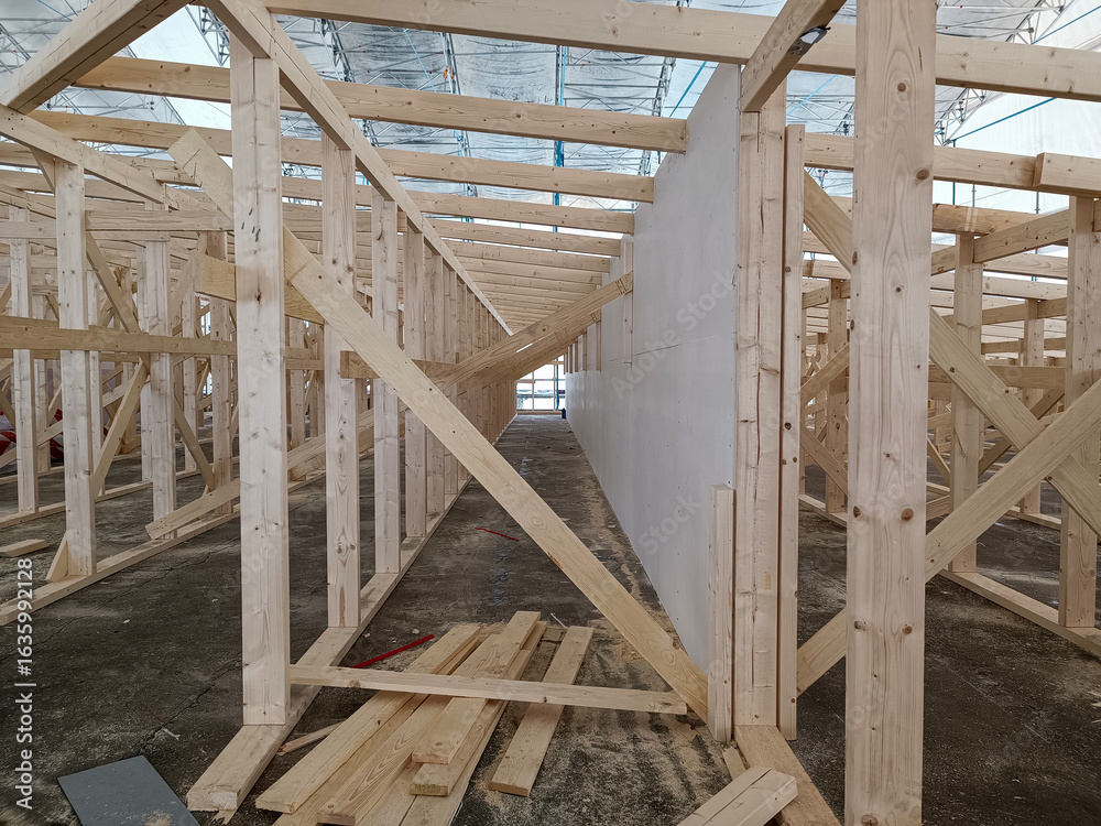 Obraz premium Construction work on the roof frame. Wooden structure made of timber. Carpenters and joiners products