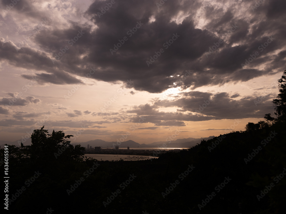 Fototapeta premium Sunset Over Mountains and Industrial Coastline with Dramatic Clouds