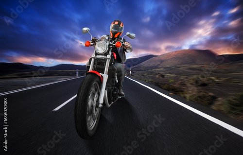 Wallpaper Mural A man is riding a motorcycle down a night road Torontodigital.ca