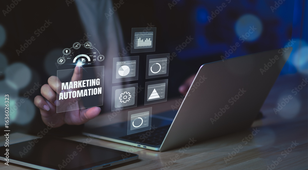 Fototapeta premium Marketing automation concept showing professional using laptop with futuristic analytics dashboard, optimizing digital campaigns, data tracking, and customer engagement in modern office setting.