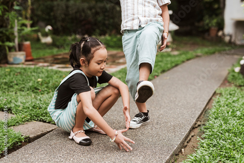 Photos Two Filipino children enjoy playing Luksong Tinik outdoors, a traditional jumping game that promotes balance, focus, and fun