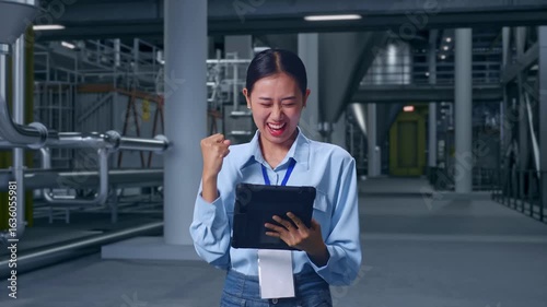 Wallpaper Mural Asian Female With Her Tablet in Distillery Interior With Large Fermentation Tanks, She Raises Her Fist Up With Screaming Goal Torontodigital.ca